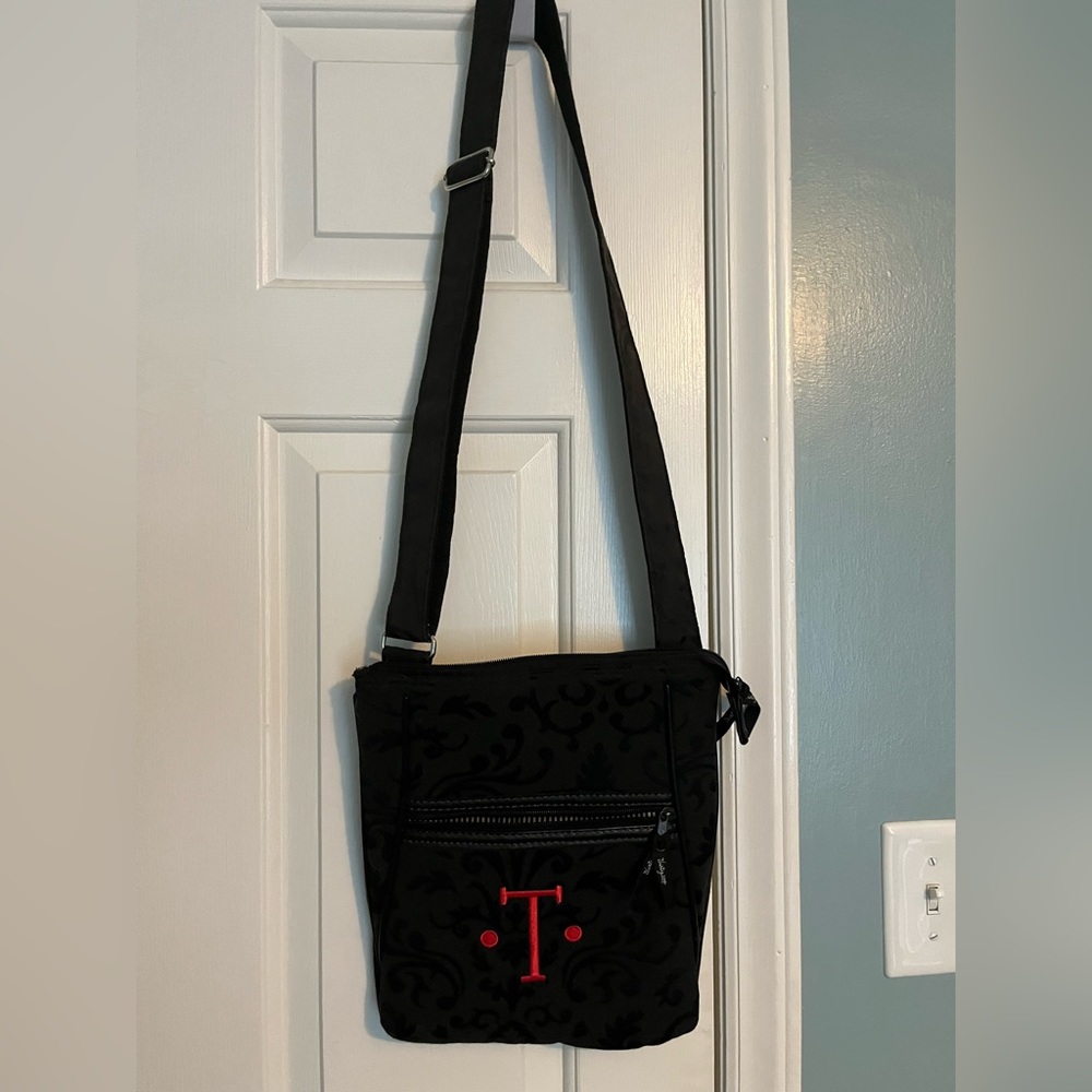Black 31 purse with initial T inscribed in red.